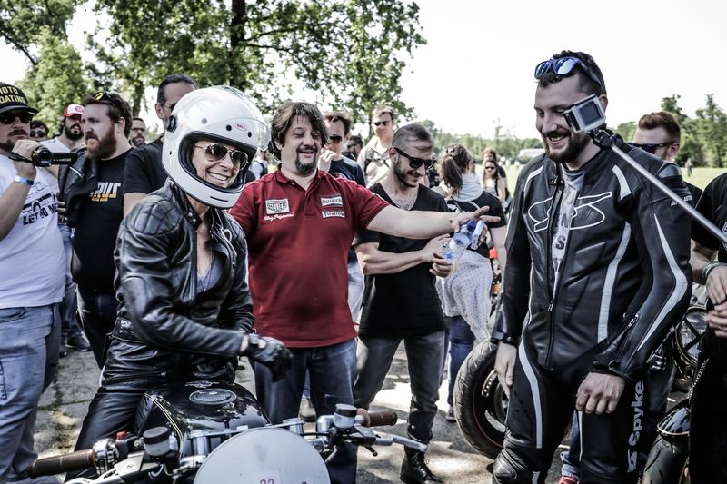 Casco bianco che ride in mezzo alla folla prima della partenza