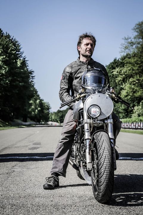 Pilota in piedi accanto alla moto in mezzo alla pista