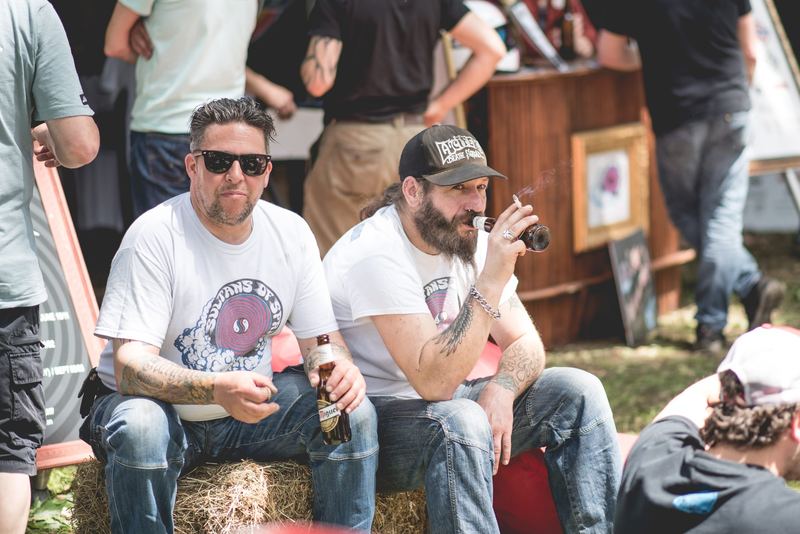 Due amici seduti sulla paglia con la birra