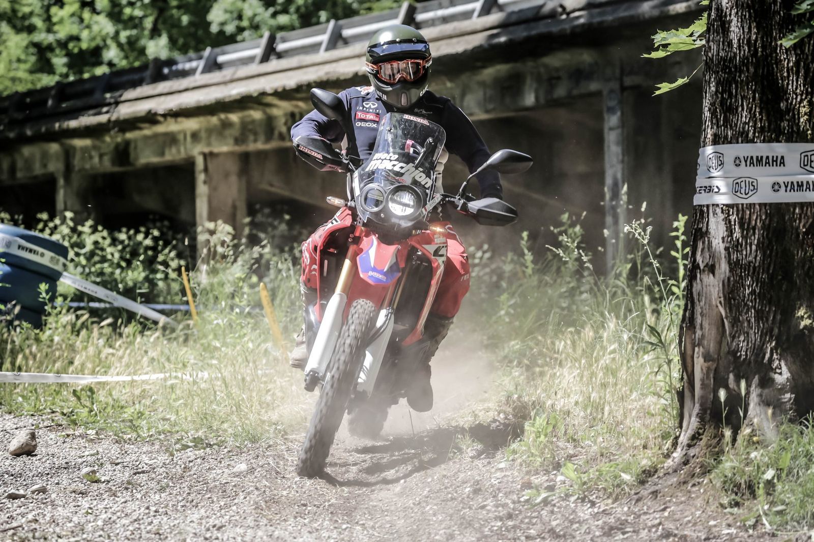 Enduro rossa nella polvere sotto la struttura della sopraelevata