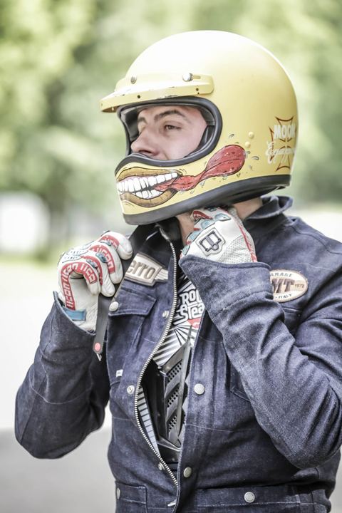 Si allaccia il casco giallo coi denti dipinti