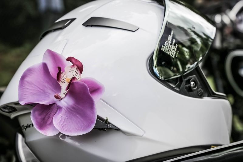 Orchidea fucsia infilata su un casco bianco