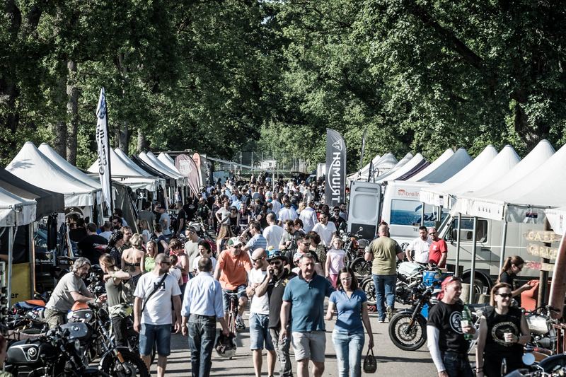 Viale del paddock tra gazebo e moto, pieno sole