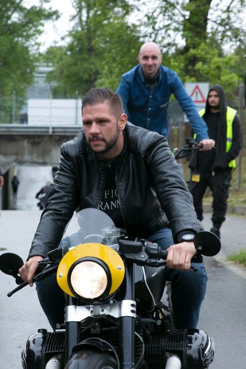 Cafe racer col faro giallo che arriva verso l'obiettivo