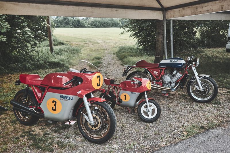Due racer d'epoca rosse numero 3 sotto il tendone